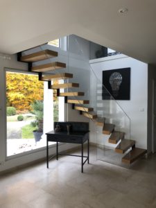 Escalier avec un limon en crémaillère marche bois et garde corps verre intégral